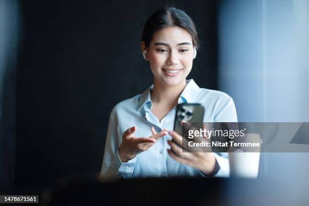 intelligent virtual connections technologies can drive your business to success. businesswoman answering or conference call with her business partner on a smartphone in an office space. - emotional intelligence stockfoto's en -beelden