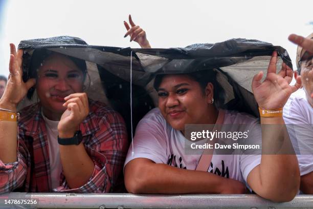 Fans shelter from the rain at Room Service with Ice Cube & Cypress Hill perform on stage on April 01, 2023 in Auckland, New Zealand.