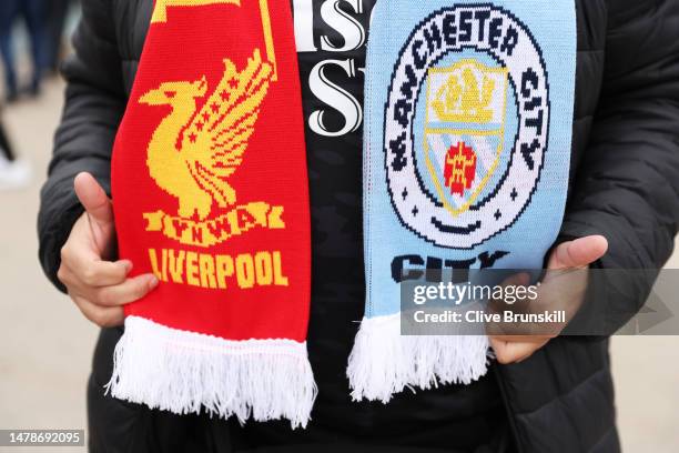 Fan wearing a half and half scarf poses for a photo outside the stadium prior to the Premier League match between Manchester City and Liverpool FC at...