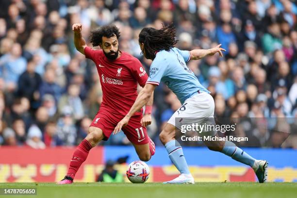 Mohamed Salah of Liverpool is challenged by Nathan Ake of Manchester City during the Premier League match between Manchester City and Liverpool FC at...