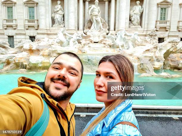 couple taking a selfie in front of the trevi fountain in rome - art of the vintage selfie stockfoto's en -beelden