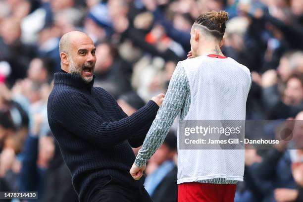 Josep 'Pep' Guardiola, manager of Manchester City, taunts Kostas Tsimikas of Liverpool as he celebrates his side's first goal during the Premier...