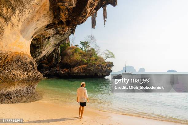 uomo che cammina sulla spiaggia di railey e guardando paesaggi mozzafiato - provincia-di-phuket foto e immagini stock