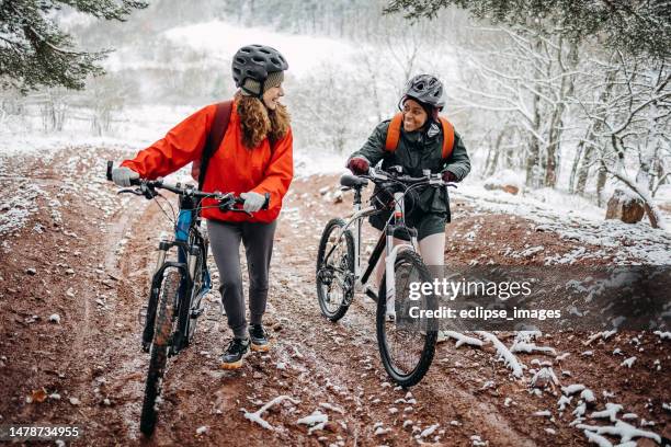 two friends in the forest with bicycles - mid adult stockfoto's en -beelden