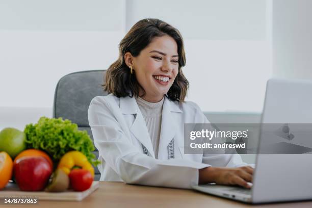 portrait of a nutritionist doctor working on the laptop - nutritionist stock pictures, royalty-free photos & images