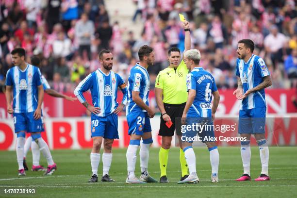 Referee Ortiz Arias shows a yellow card to Denis Suarez of RCD Espanyol and a red card to Sergi Gomez of RCD Espanyol during the LaLiga Santander...