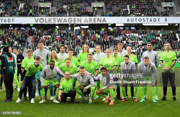 Players of VfL Wolfsburg pose for a photo with mascots prior to the Bundesliga match between VfL Wolfsburg and FC Augsburg at Volkswagen Arena on...