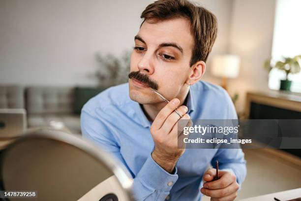 mann trimmt seinen schnurrbart - schnauzer stock-fotos und bilder