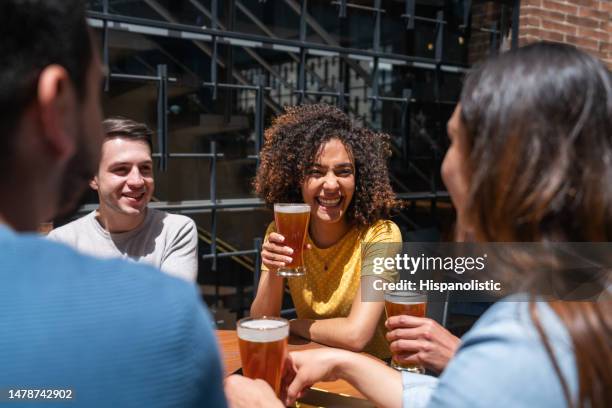 mujer feliz divirtiéndose en un bar bebiendo cervezas con amigos - artisanal food and drink fotografías e imágenes de stock