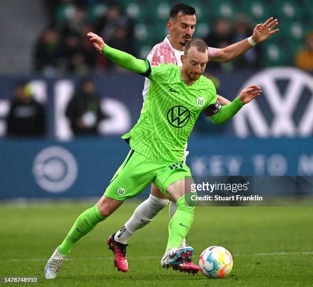 Maximilian Arnold of VfL Wolfsburg is challenged by Meargim Berisha of FC Augsburg during the Bundesliga match between VfL Wolfsburg and FC Augsburg...