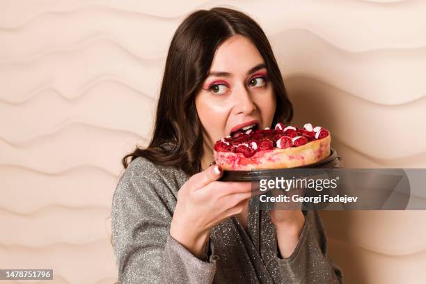 close up portrait of a hungry young pregnant woman going to eat chocolate cake isolated on a gray background - big lips fotografías e imágenes de stock