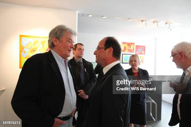 Alain Delon and French President Francois Hollande attend the opening of the exhibition of Florence Cassez, the French citizen emprisoned in Mexico.