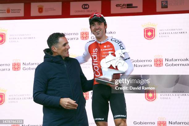 Miguel Indurain of Spain Ex Pro-Cyclist hands over the trophy to race winner Ion Izaguirre of Spain and Team Cofidis at the podium ceremony during...