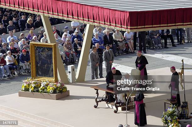 Pope John Paul II sits near a painting known as the Madonna del Rosario's as he signs the document which makes official changes to the Catholic...