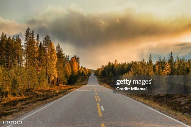 an approaching storm over an empty road in north finland at autumn - dichterbij komen stockfoto's en -beelden