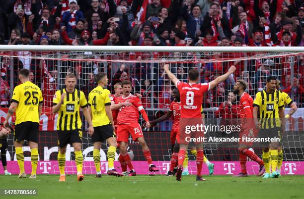 Thomas Mueller of FC Bayern Munich celebrates with teammates after scoring the team's second goal during the Bundesliga match between FC Bayern...