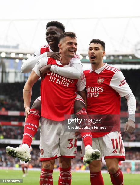 Granit Xhaka of Arsenal celebrates with teammates Bukayo Saka and Gabriel Martinelli after scoring the team's fourth goal during the Premier League...