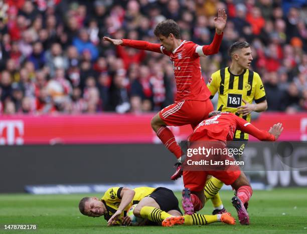 Julian Ryerson of Borussia Dortmund is challenged by Thomas Mueller and Eric Maxim Choupo-Moting of FC Bayern Munich during the Bundesliga match...