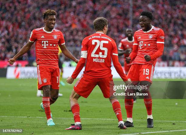 Thomas Mueller of FC Bayern Munich celebrates with teammates Kingsley Coman and Alphonso Davies after scoring the team's third goal during the...