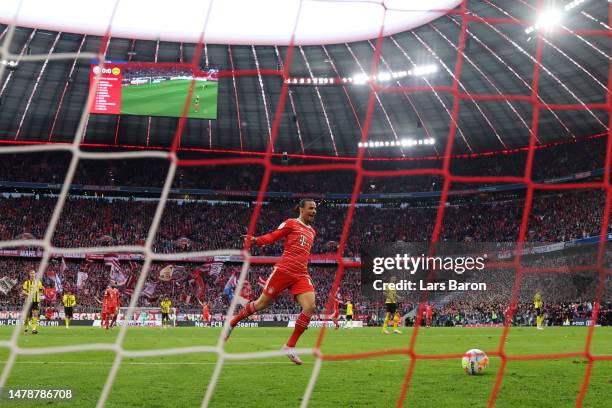 Leroy Sane of FC Bayern Munich celebrates their team's first goal, an own goal scored by Gregor Kobel of Borussia Dortmund during the Bundesliga...