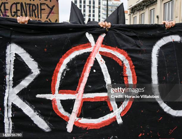 Demonstrators parade behind an Anarchist banner during the "Casa Para Viver" protest on April 01, 2023 in Lisbon, Portugal. Demonstrations for the...