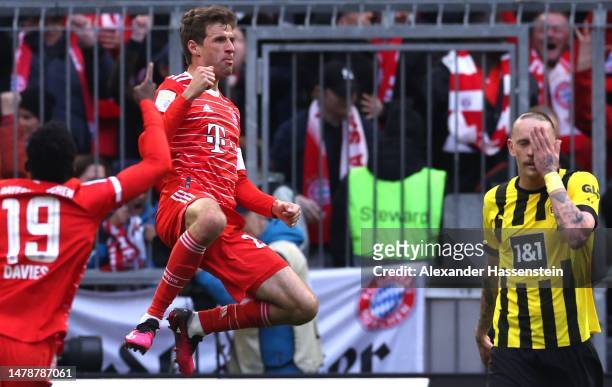 Marius Wolf of Borussia Dortmund reacts as Thomas Mueller of FC Bayern Munich celebrates after scoring the team's second goal during the Bundesliga...
