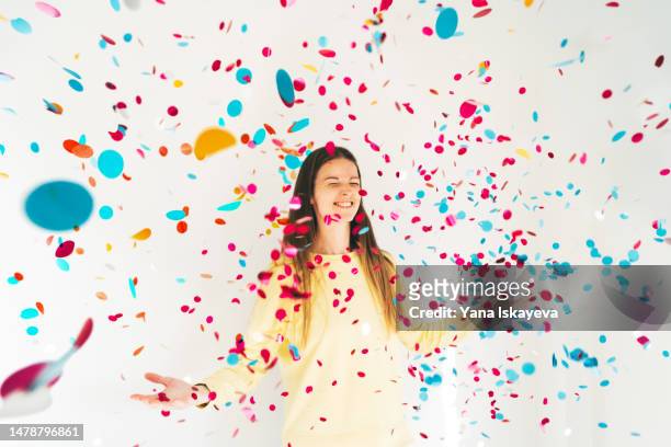 a beautiful woman blowing confetti at the camera, wide angle, festive concepts - rainbow confetti stock pictures, royalty-free photos & images