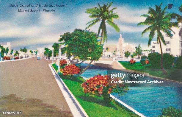 Vintage colorized historic souvenir photo postcard published circa 1945 as part of a series titled, 'Miami Beach,' depicting a view of the waters of...