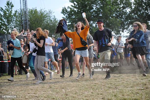 Festival goers run into the festival area, as the gates of the annual Roskilde Festival open in Roskilde, on July 5, 2012. The festival runs till...