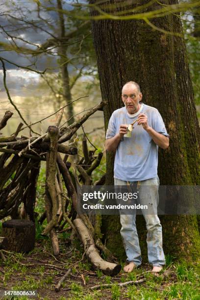 elderly homeless man camping out in the woods - homeless person stock pictures, royalty-free photos & images