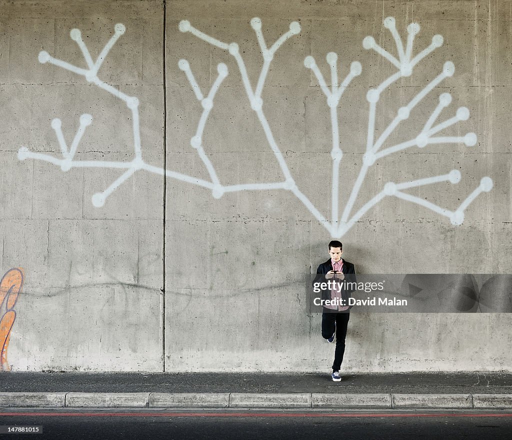 Social network on a wall behind a young man