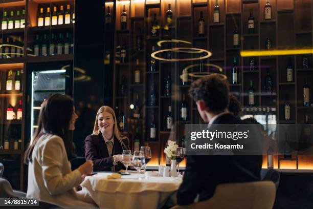 four business people hang out during a business dinner in a restaurant - global leadership dinner stock pictures, royalty-free photos & images