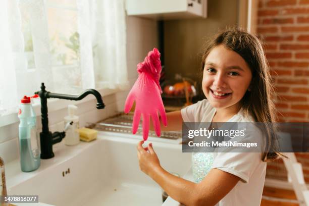 mädchen, das spaß mit gummihandschuhen in der küche hat - kids with cleaning rubber gloves stock-fotos und bilder