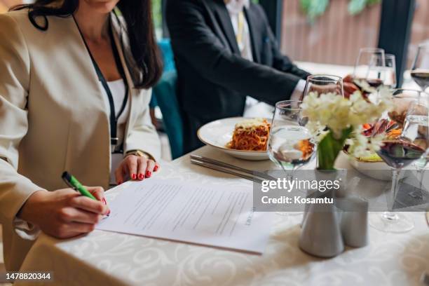 business people gathered at a business dinner to sign a contract and establish cooperation with a client - global leadership dinner stock pictures, royalty-free photos & images