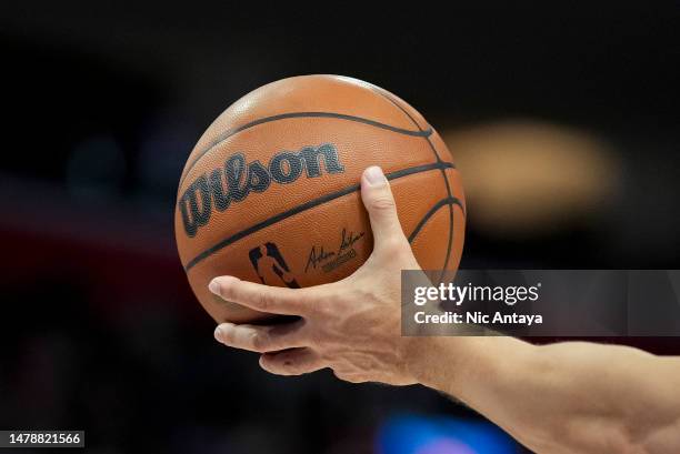 Referee holds a Wilson brand official NBA game ball basketball during the game between the Detroit Pistons and Milwaukee Bucks at Little Caesars...