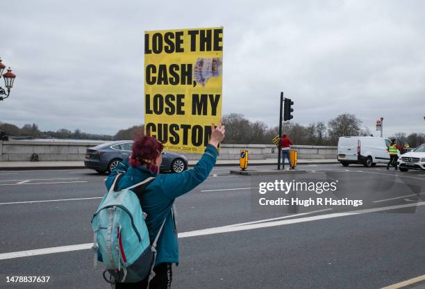 Protester demonstrates against the rise of the cashless society and increase in the digital economy on April 01, 2023 on Putney Bridge, in Putney,...