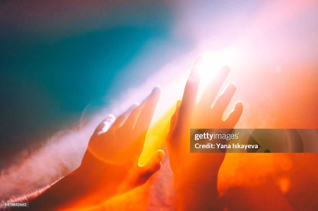 Human hands stretched out to the burning sun, ethereal and unreal concepts of Universe, spiritual and natural powers