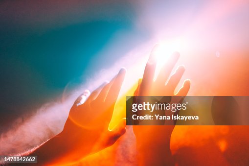 Human hands stretched out to the burning sun, ethereal and unreal concepts of Universe, spiritual and natural powers