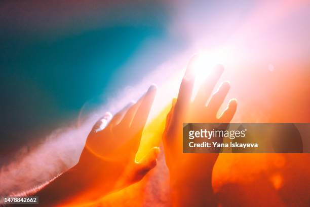 human hands stretched out to the burning sun, ethereal and unreal concepts of universe, spiritual and natural powers - spirituality imagens e fotografias de stock