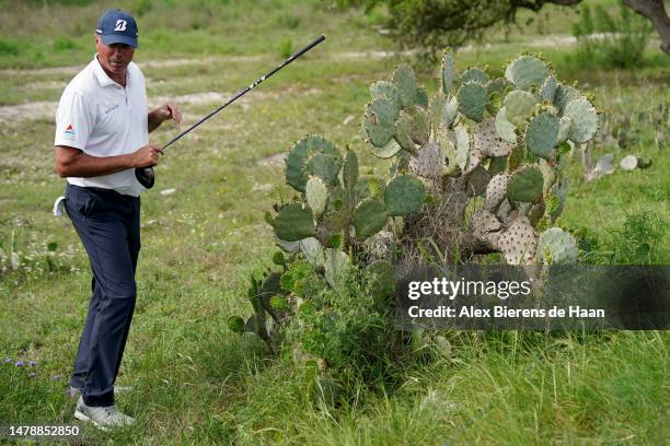 Matt Kuchar of the United States inspects the lie of his ball on the 18th hole during the third round of the Valero Texas Open at TPC San Antonio on...