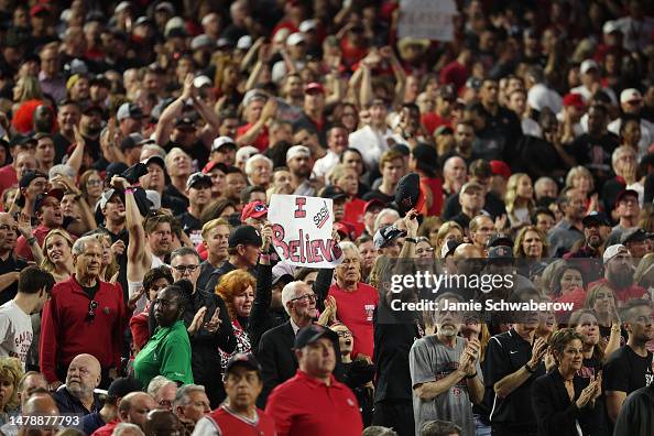 Fans of the San Diego State Aztecs hold up signs and clap during the ...