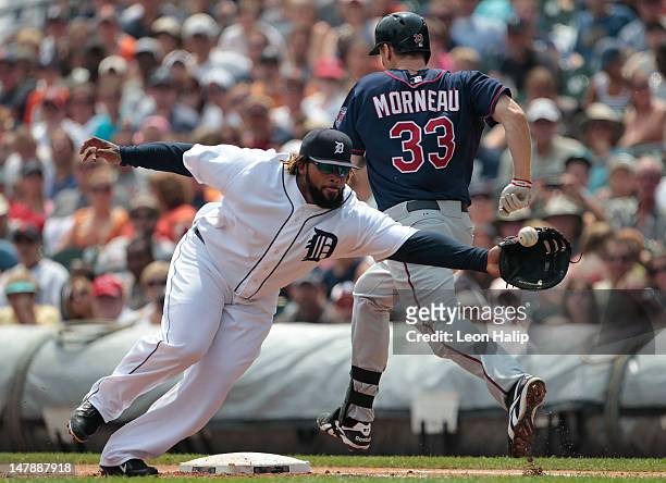 Justin Morneau of the Minnnesota Twins beats the throw to first base as Prince Fielder of the Detroit Tigers stretches to make the play during the...