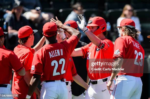 Charlie Condon of the Georgia Bulldogs high fives teammate Dwight Allen II and Connor Tate against the Vanderbilt Commodores at Hawkins Field on...