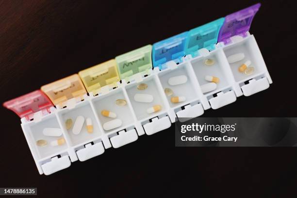 medication and supplements in pill organizer - opening week stock pictures, royalty-free photos & images