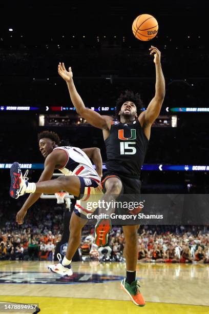 Nahiem Alleyne of the Connecticut Huskies and Norchad Omier of the Miami Hurricanes battle during the first half during the NCAA Men's Basketball...