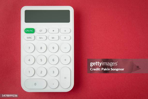 white calculator with copy space against a red background. - mechanical calculator photos et images de collection