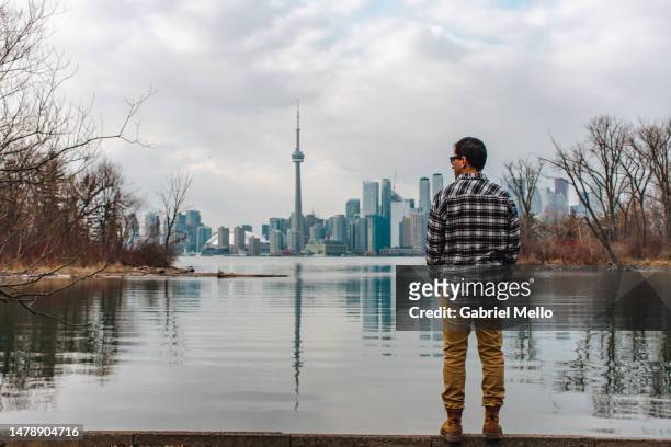 rear view of man standing staring the views of toronto - toronto winter stock pictures, royalty-free photos & images