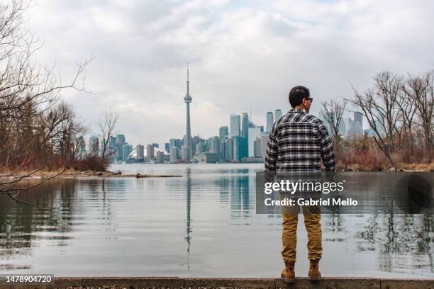 rear view of man standing staring the views of toronto - lake ontario stock-fotos und bilder