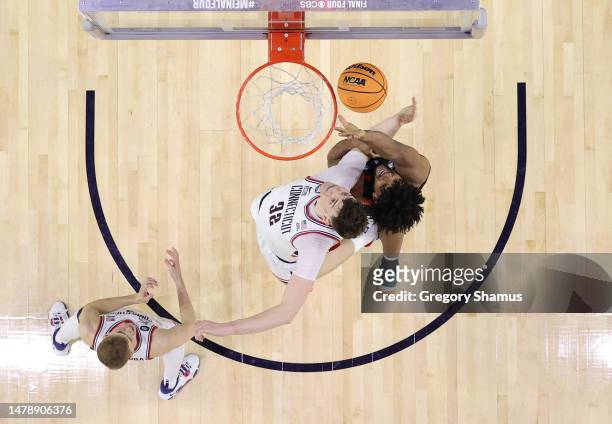 Donovan Clingan of the Connecticut Huskies and Norchad Omier of the Miami Hurricanes battle for the ball during the second half during the NCAA Men's...