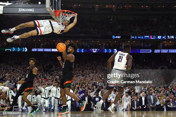 Andre Jackson Jr. #44 of the Connecticut Huskies hangs on to the rim after dunking the ball during the second half against the Miami Hurricanes...